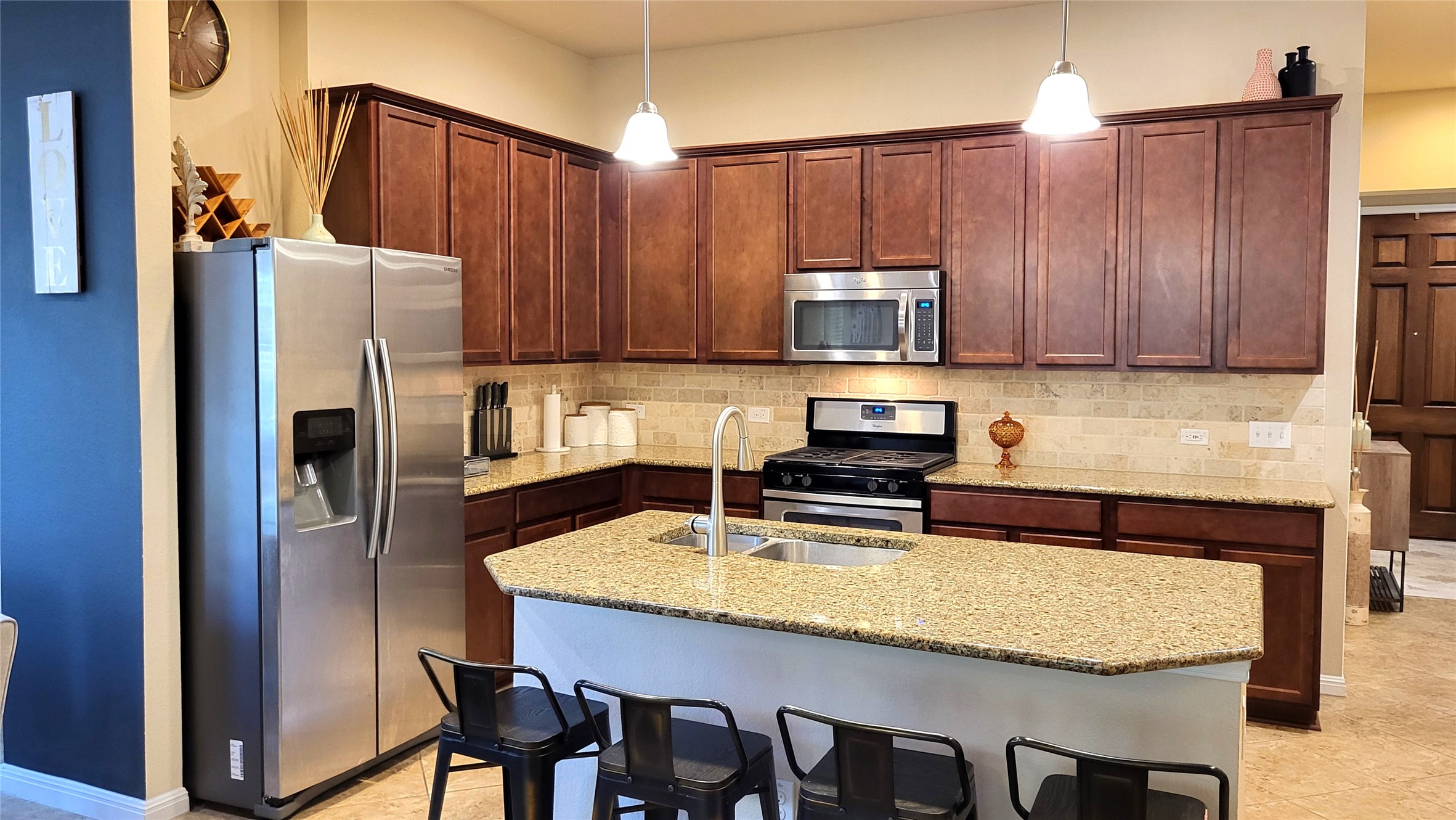 413 Anacua Loop, Unit 8 Manchaca, TX 78652 - Photo 8 of 23 Rich wood cabinetry and a granite-topped prep island anchor this functional workspace.