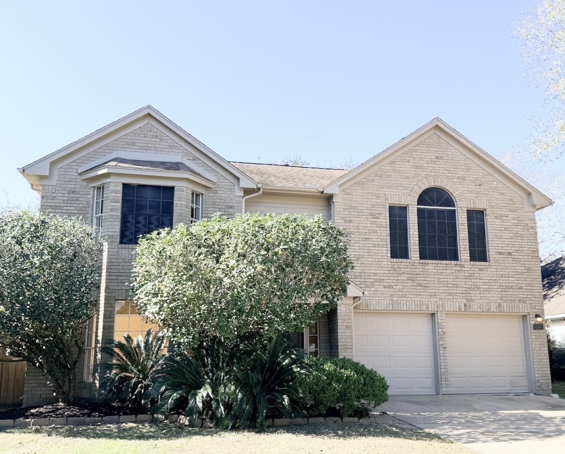 a view of a house with a yard and large tree