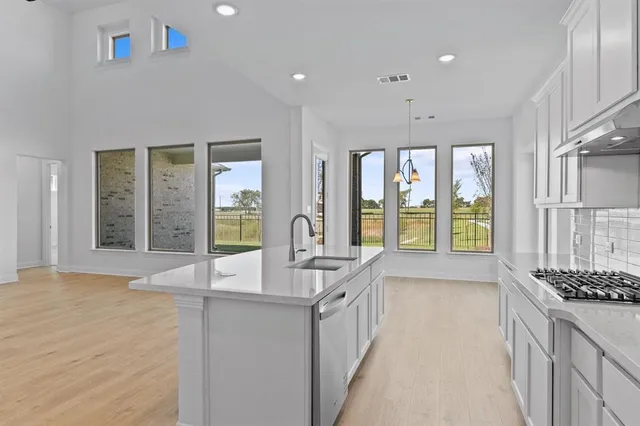 a kitchen with stainless steel appliances granite countertop a refrigerator and a stove top oven