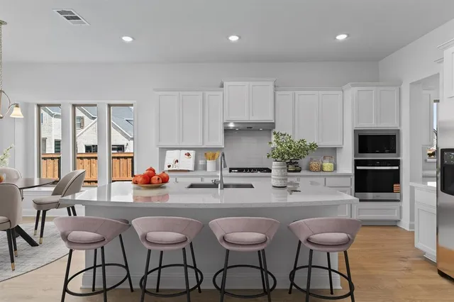 a kitchen with stainless steel appliances white cabinets and a refrigerator