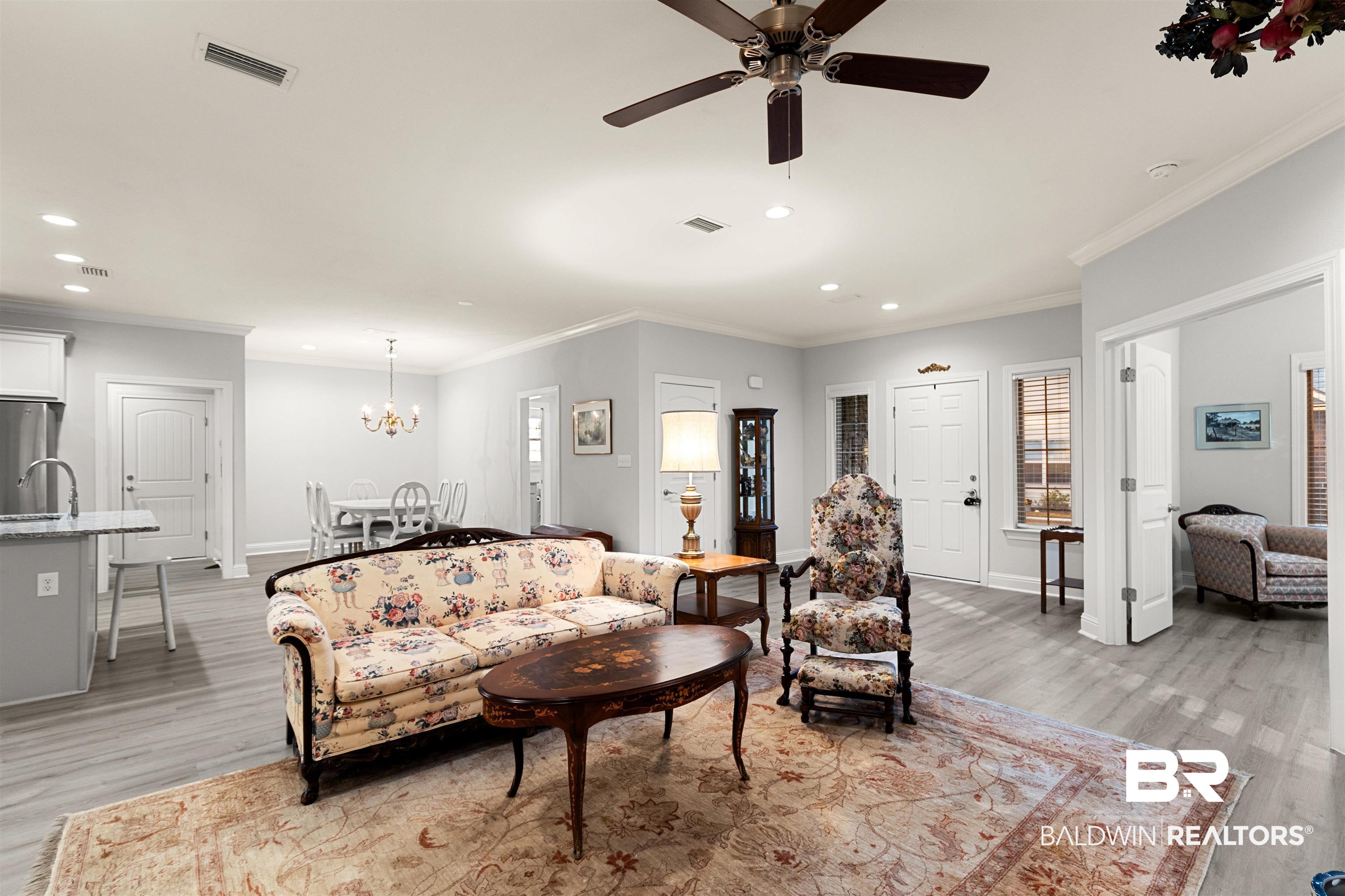 702 Holmes Avenue, Unit 702 Foley, AL 36535 - Photo 4 of 33 Living room featuring ceiling fan with notable chandelier, ornamental molding, light hardwood / wood-style floors, and sink
