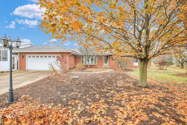 a front view of a house with a yard covered with snow
