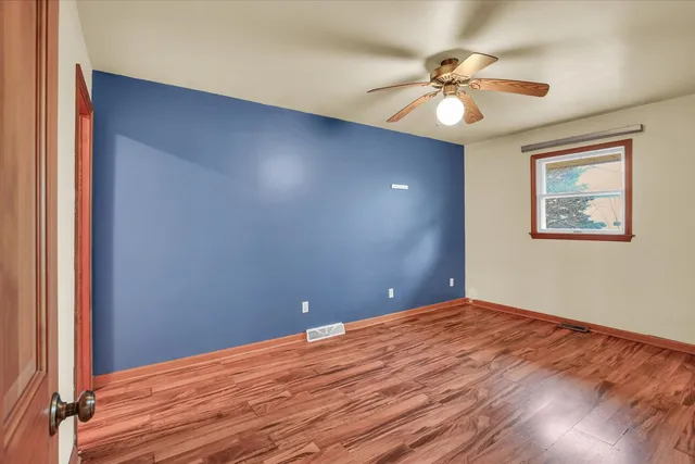 an empty room with wooden floor and door
