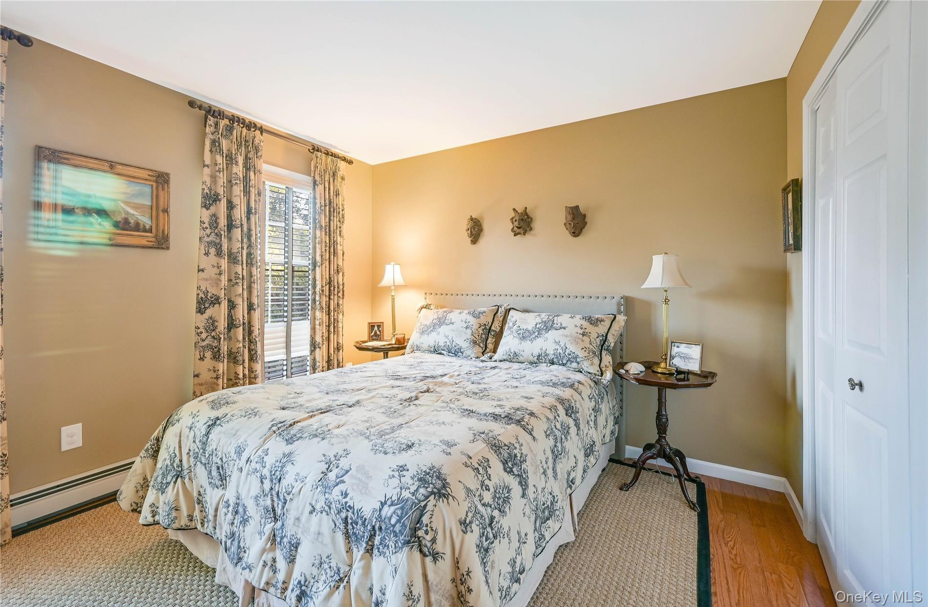 215 Kouros Road New Suffolk, NY 11956 - Photo 16 of 28 a bedroom with a bed and wooden floor