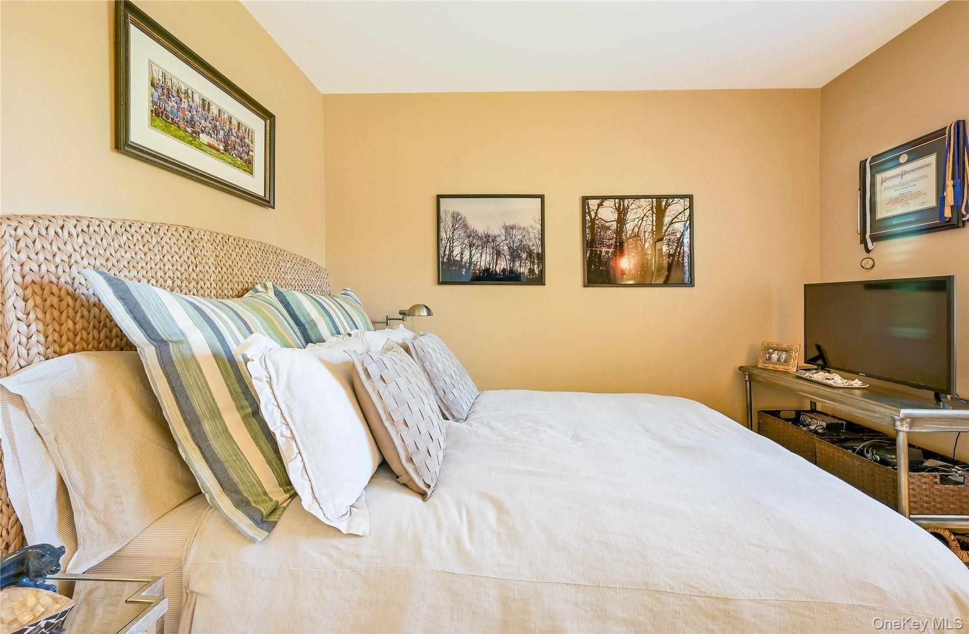 215 Kouros Road New Suffolk, NY 11956 - Photo 22 of 28 a bedroom with a bed and a flat screen tv