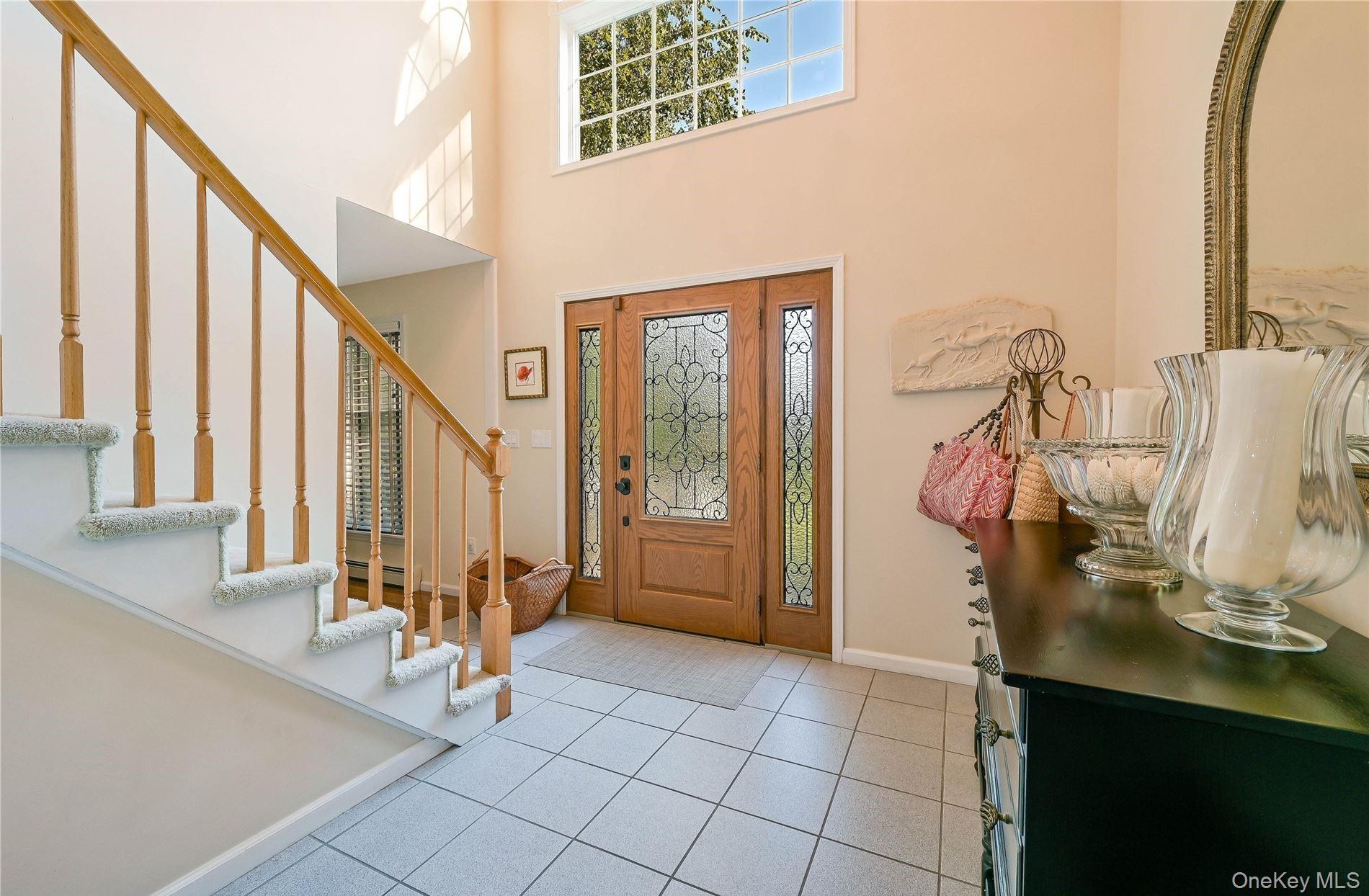 215 Kouros Road New Suffolk, NY 11956 - Photo 3 of 28 a view of a hallway with windows and chandelier