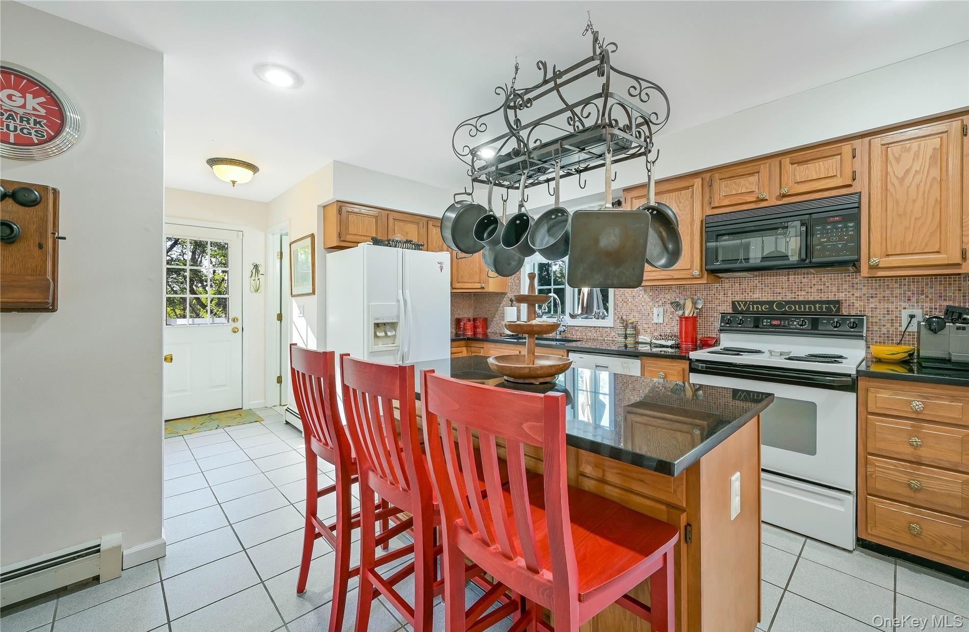215 Kouros Road New Suffolk, NY 11956 - Photo 10 of 28 a kitchen with stainless steel appliances granite countertop a sink and a refrigerator