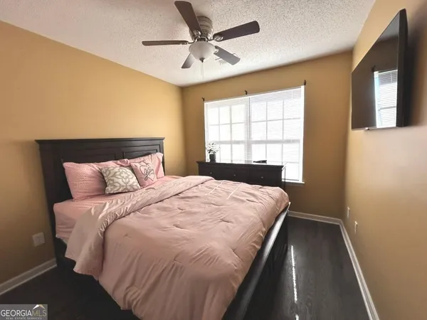 a bedroom with a large bed and a ceiling fan