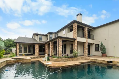 a view of house with swimming pool and chairs