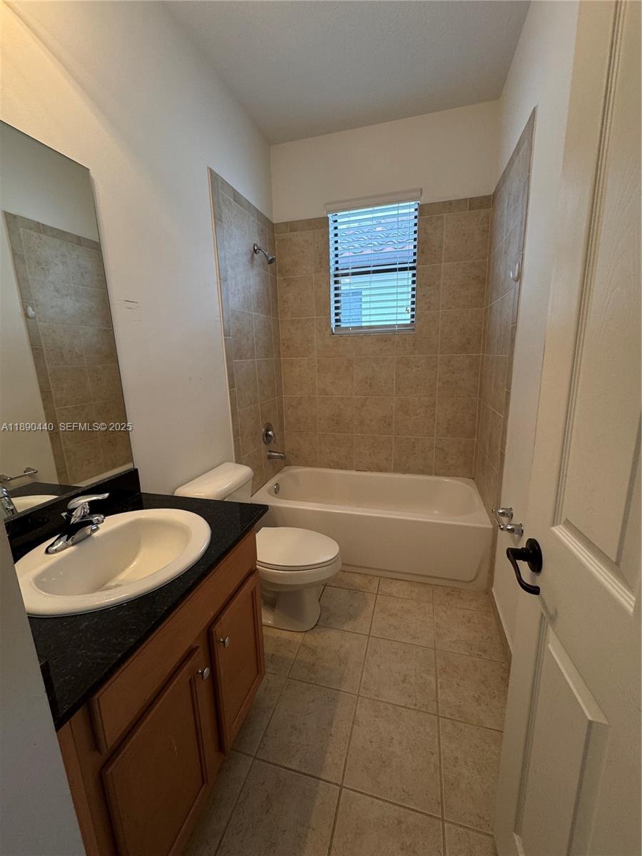 9079 Southwest 35th Street Miramar, FL 33025 - Photo 18 of 21 a bathroom with a granite countertop sink a toilet and bathtub