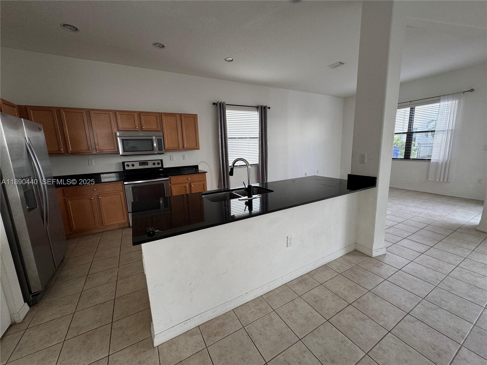 9079 Southwest 35th Street Miramar, FL 33025 - Photo 2 of 21 a kitchen with stainless steel appliances a sink a stove a microwave a sink a refrigerator and cabinets