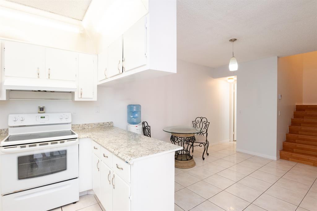 3118 Spanish Wells Drive, Unit 15C Delray Beach, FL 33445 - Photo 11 of 40 a kitchen with a stove a sink and a refrigerator