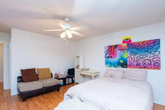 a bedroom with a bed couch and a chandelier