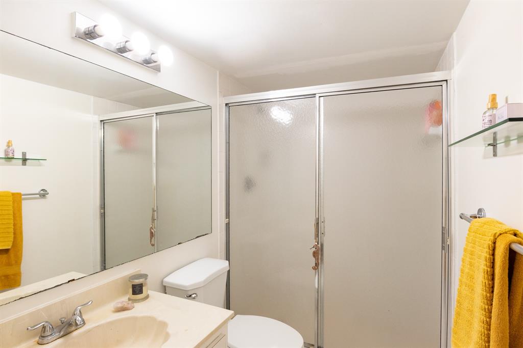 3118 Spanish Wells Drive, Unit 15C Delray Beach, FL 33445 - Photo 25 of 40 a bathroom with a sink mirror vanity and toilet