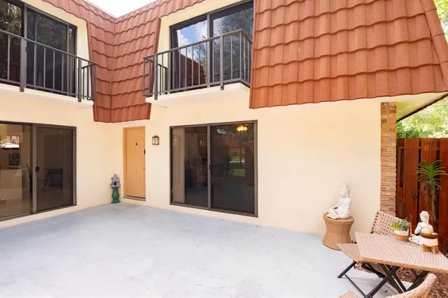 a patio with a table and chairs under an umbrella