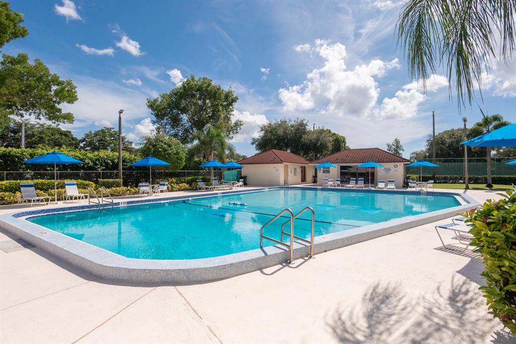 3118 Spanish Wells Drive, Unit 15C Delray Beach, FL 33445 - Photo 29 of 40 a view of a swimming pool with a yard