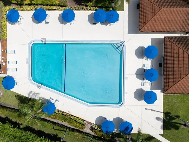 an aerial view of residential house with outdoor space and trees all around