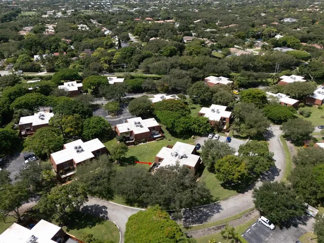 an aerial view of residential house with outdoor space and trees all around