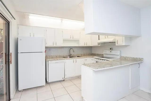 a kitchen with a refrigerator sink stove and cabinets