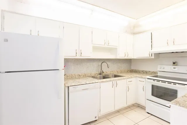 a kitchen with a white cabinets and white appliances