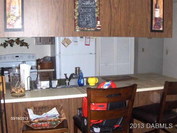 5494 Riverside Drive Port Orange, FL 32127 - Photo 4 of 13 a kitchen with a dining table and appliances