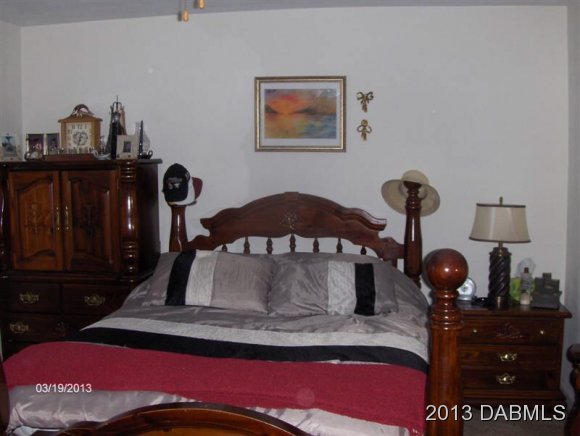 5494 Riverside Drive Port Orange, FL 32127 - Photo 9 of 13 a bedroom with a bed and cabinets