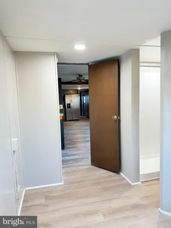 a view of a hallway with wooden floor and closet