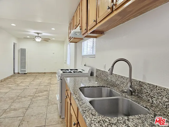 a kitchen with a sink a stove and cabinets
