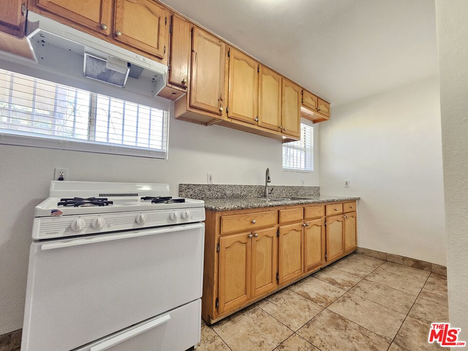 204 North Spring Avenue Compton, CA 90221 - Photo 4 of 14 a kitchen with granite countertop a sink stove and cabinets