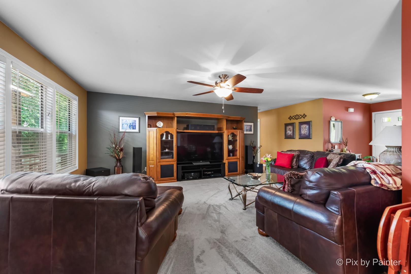 336 Claire Lane Cary, IL 60013 - Photo 15 of 29 a living room with furniture ceiling fan and a large window