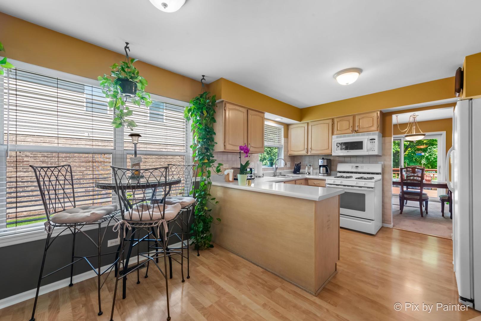 336 Claire Lane Cary, IL 60013 - Photo 19 of 29 a kitchen with a table chairs stove and cabinets