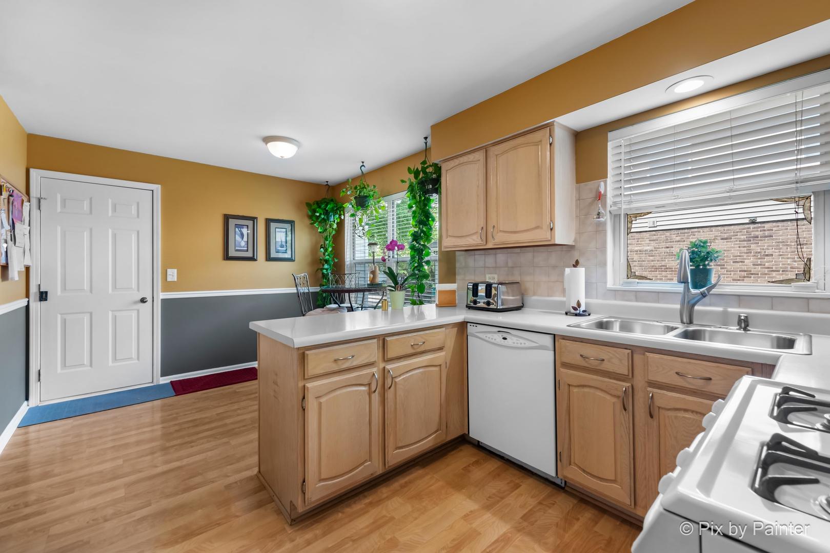 336 Claire Lane Cary, IL 60013 - Photo 21 of 29 a kitchen with a sink cabinets and wooden floor