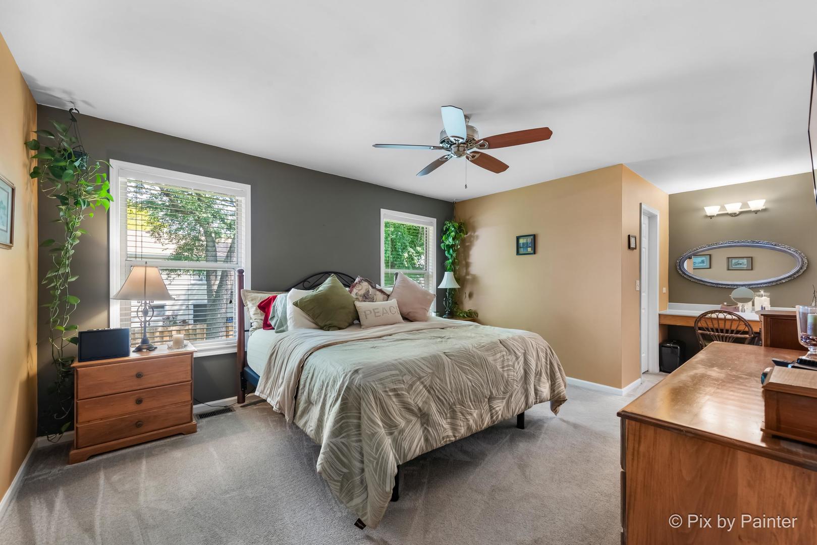 336 Claire Lane Cary, IL 60013 - Photo 23 of 29 a spacious bedroom with a bed a window and a chandelier