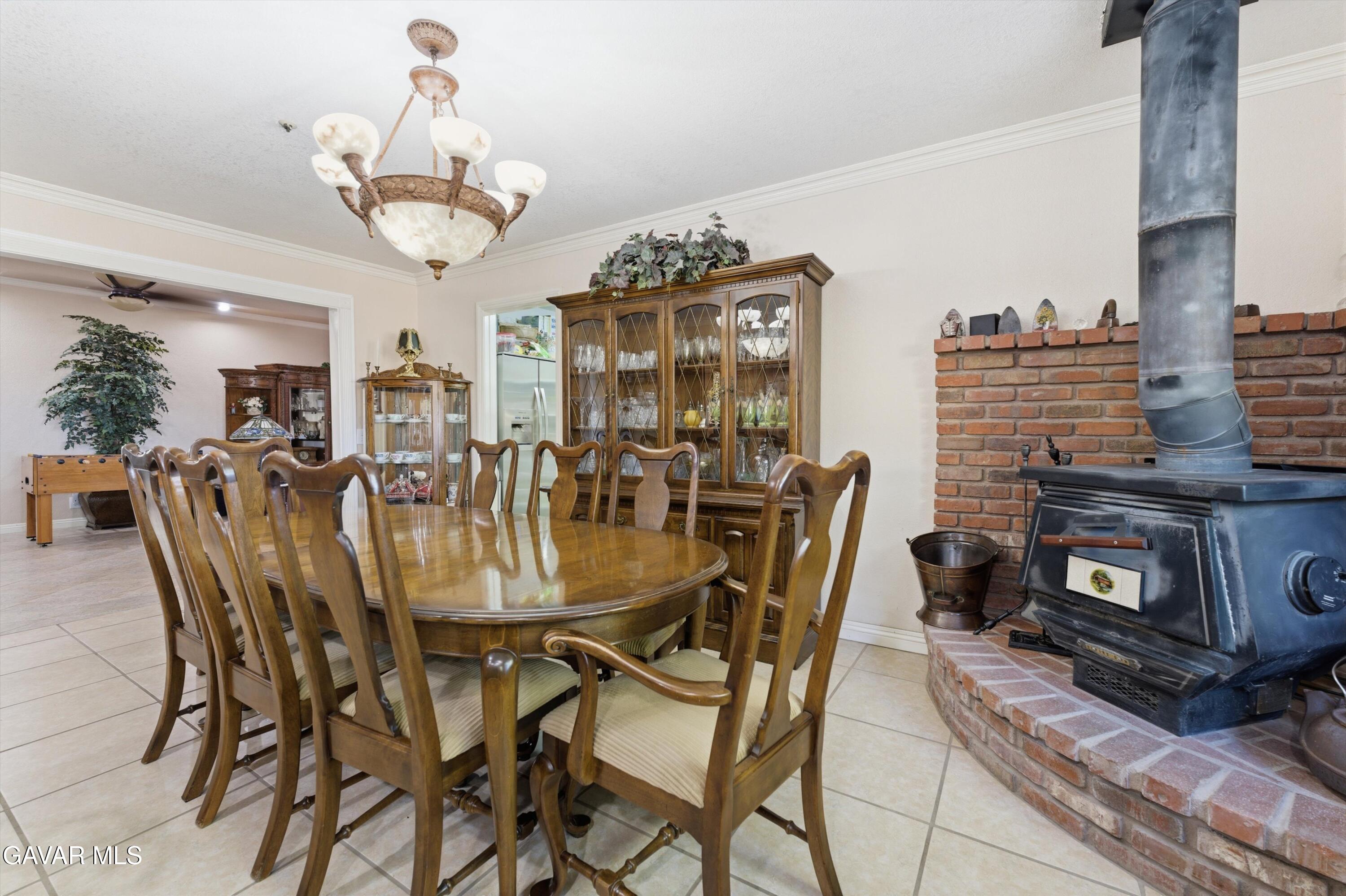 5801 Hacienda Ranch Road Palmdale, CA 93551 - Photo 19 of 69 a dining room with furniture a chandelier and fireplace
