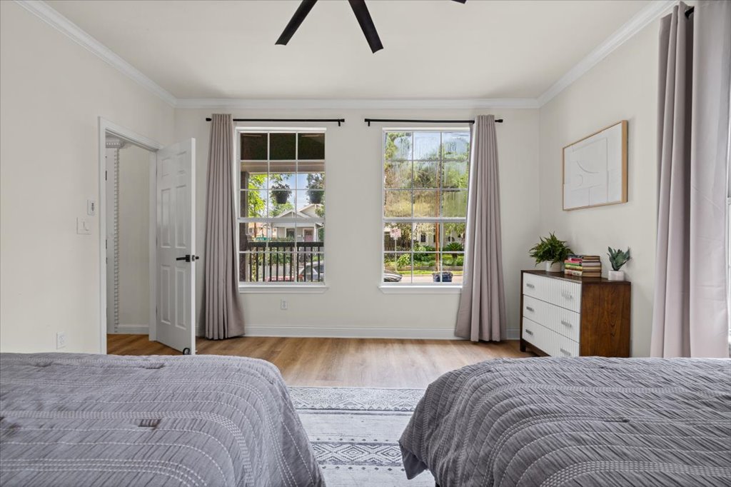 1201 Garden Street, Unit A Austin, TX 78702 - Photo 19 of 30 Dual windows offering natural light, crown molding, wood-finish flooring, a ceiling fan, and a paneled door