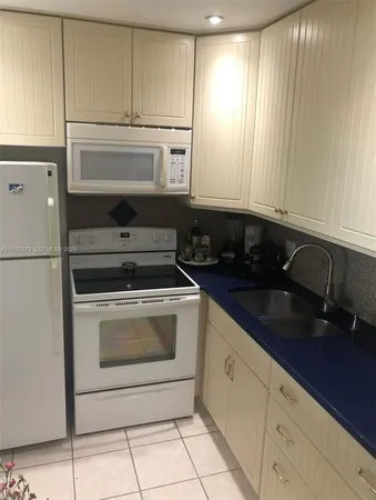 a kitchen with granite countertop white cabinets and stainless steel appliances