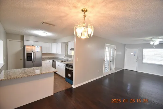 a kitchen with granite countertop a stove a sink and a microwave