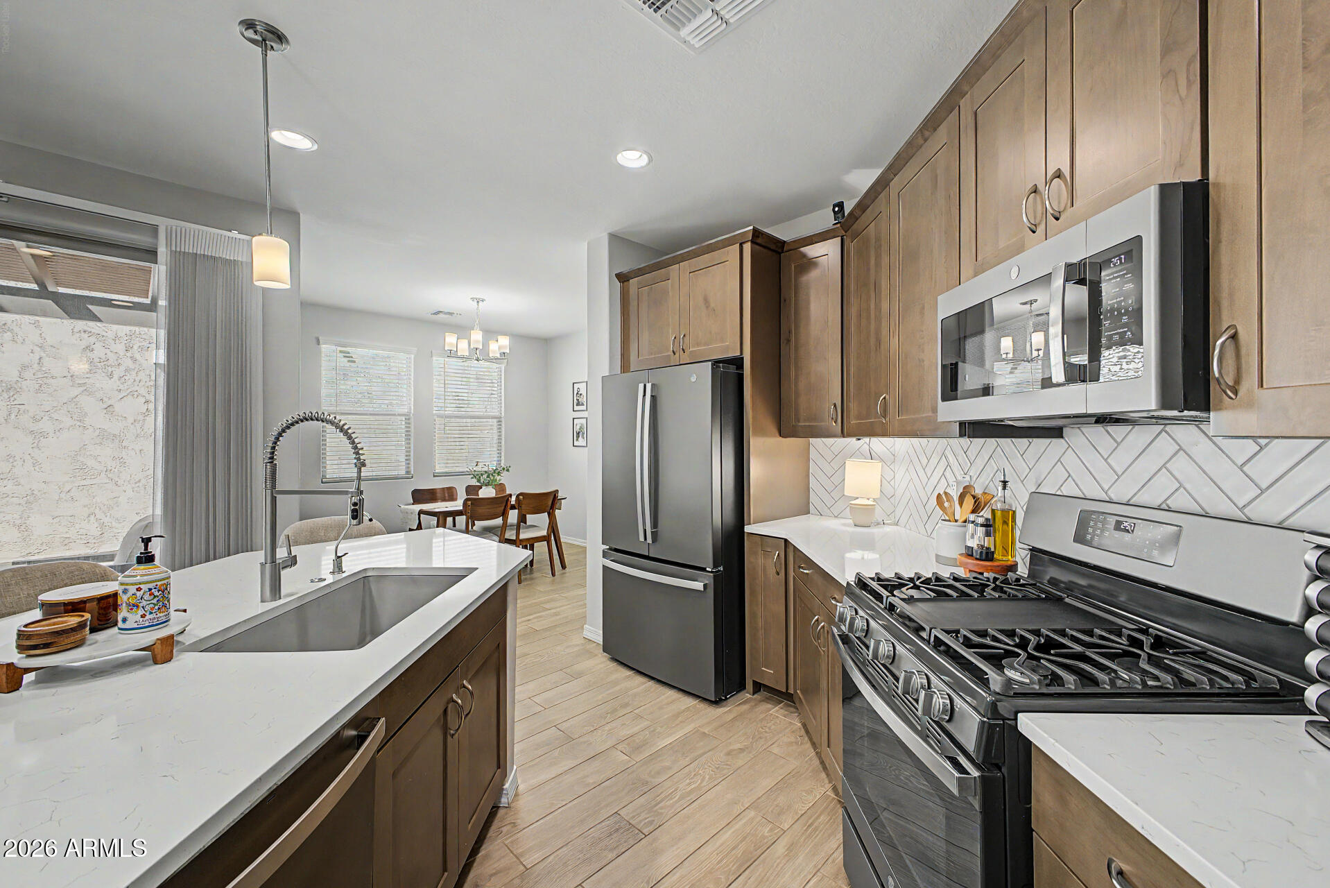 2583 South Entwistle Street Gilbert, AZ 85295 - Photo 10 of 42 a kitchen with stainless steel appliances granite countertop a sink stove and refrigerator