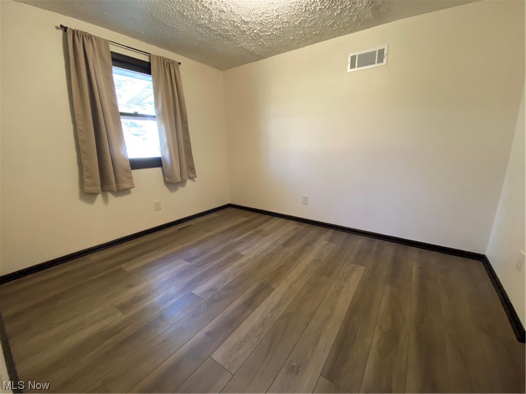 23551 Sandy Creek Road Minerva, OH 44657 - Photo 20 of 35 Empty room with dark hardwood / wood-style flooring and a textured ceiling