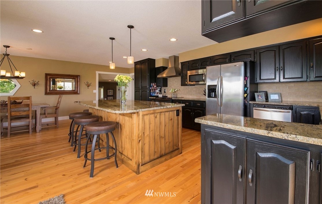 205 West Wiser Lake Road Ferndale, WA 98248 - Photo 7 of 24 a kitchen with stainless steel appliances granite countertop a sink a stove a refrigerator and island with wooden floor
