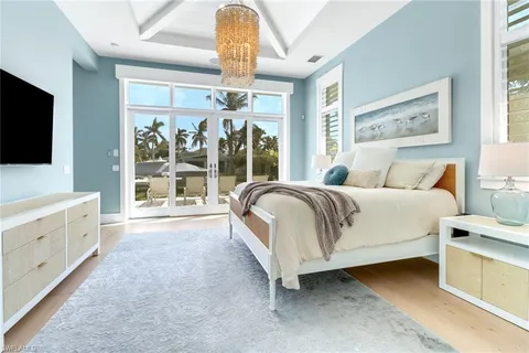 a spacious bedroom with a large bed and a flat tv screen on dresser