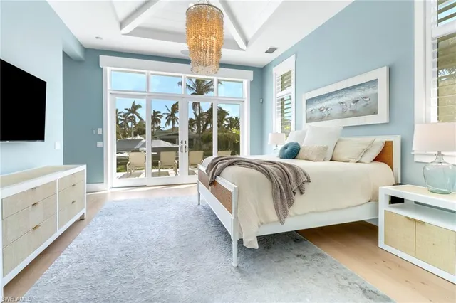 a spacious bedroom with a large bed and a flat tv screen on dresser