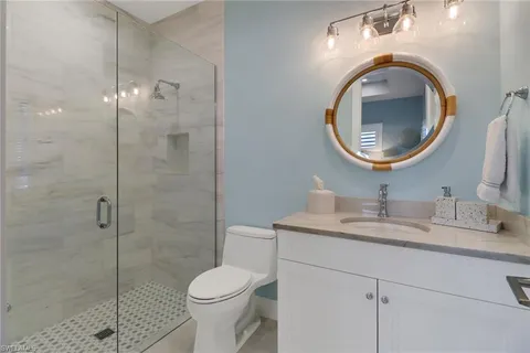 a bathroom with a toilet sink vanity and mirror