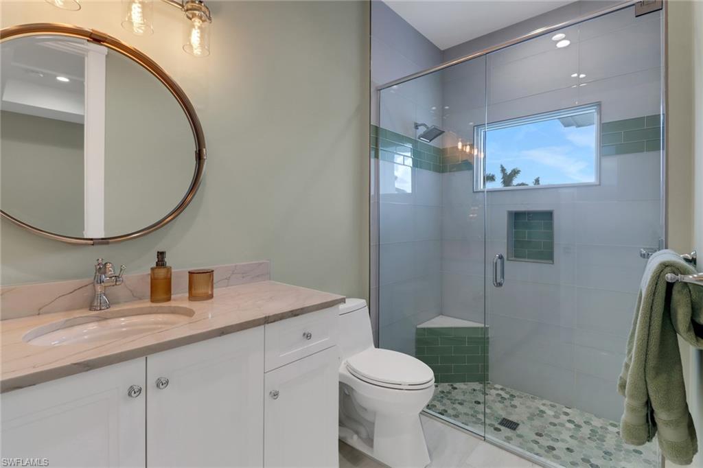 1300 Cobia Court Naples, FL 34102 - Photo 26 of 41 a bathroom with a sink a toilet and a mirror