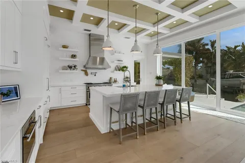 a large white kitchen with a sink and cabinets
