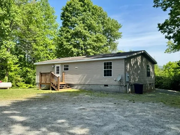 a view of a house with backyard and trees