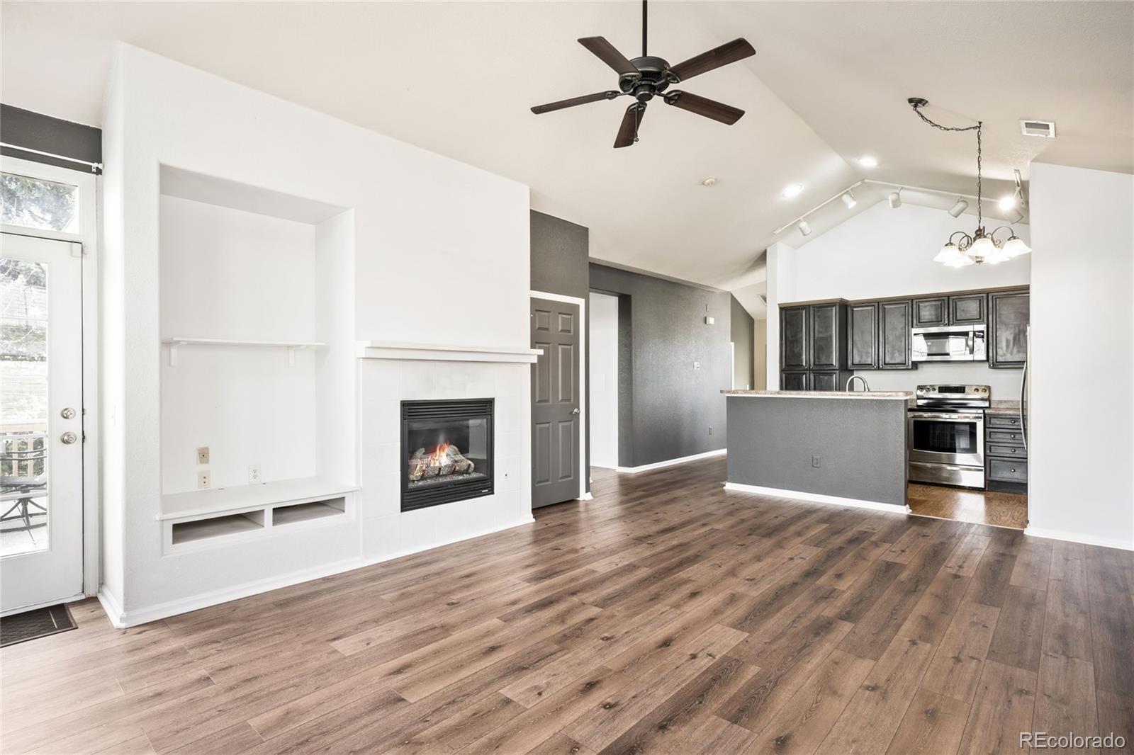 2240 South Vaughn Way, Unit 201 Aurora, CO 80014 - Photo 1 of 34 a view of a kitchen with a refrigerator a ceiling fan and wooden floor