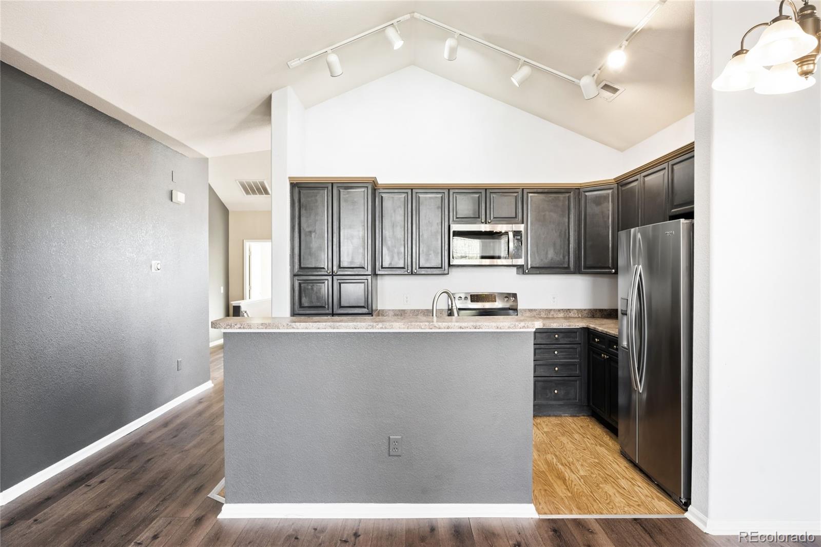 2240 South Vaughn Way, Unit 201 Aurora, CO 80014 - Photo 12 of 34 a kitchen with kitchen island a sink stainless steel appliances and cabinets