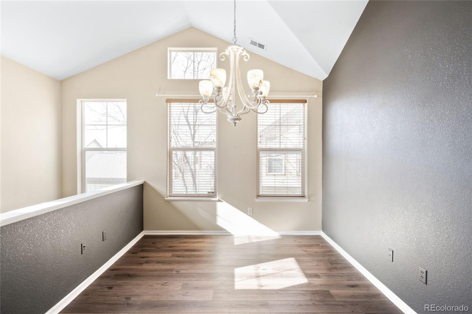 2240 South Vaughn Way, Unit 201 Aurora, CO 80014 - Photo 5 of 34 a view of an empty room with wooden floor and a window