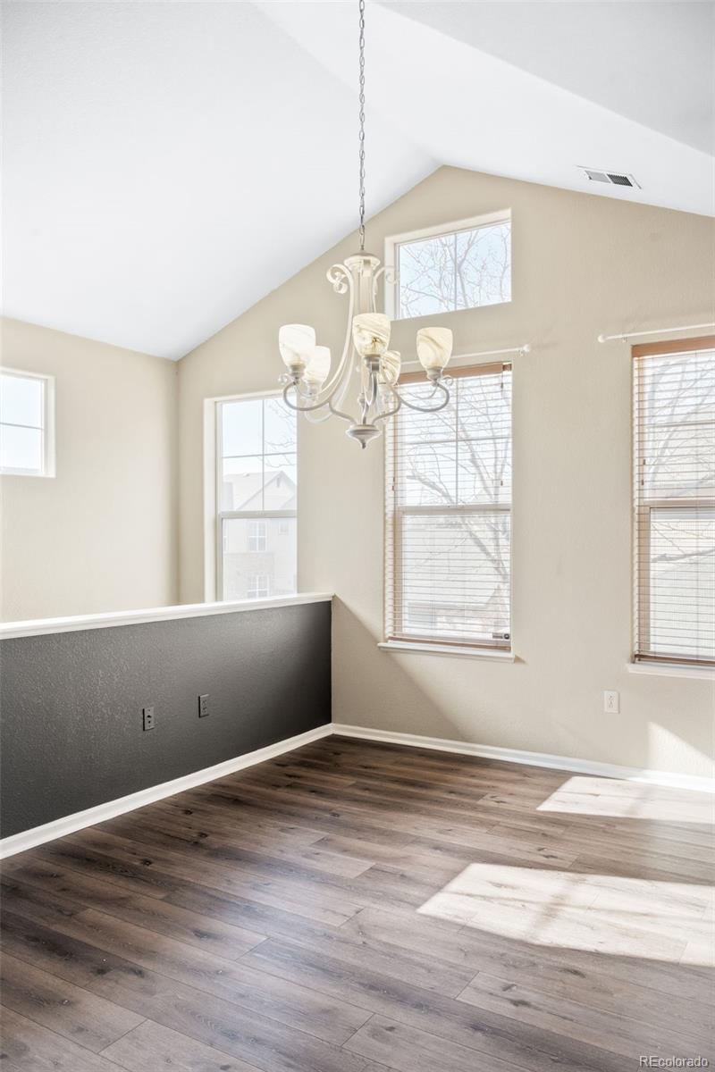 2240 South Vaughn Way, Unit 201 Aurora, CO 80014 - Photo 8 of 34 an empty room with wooden floor and windows